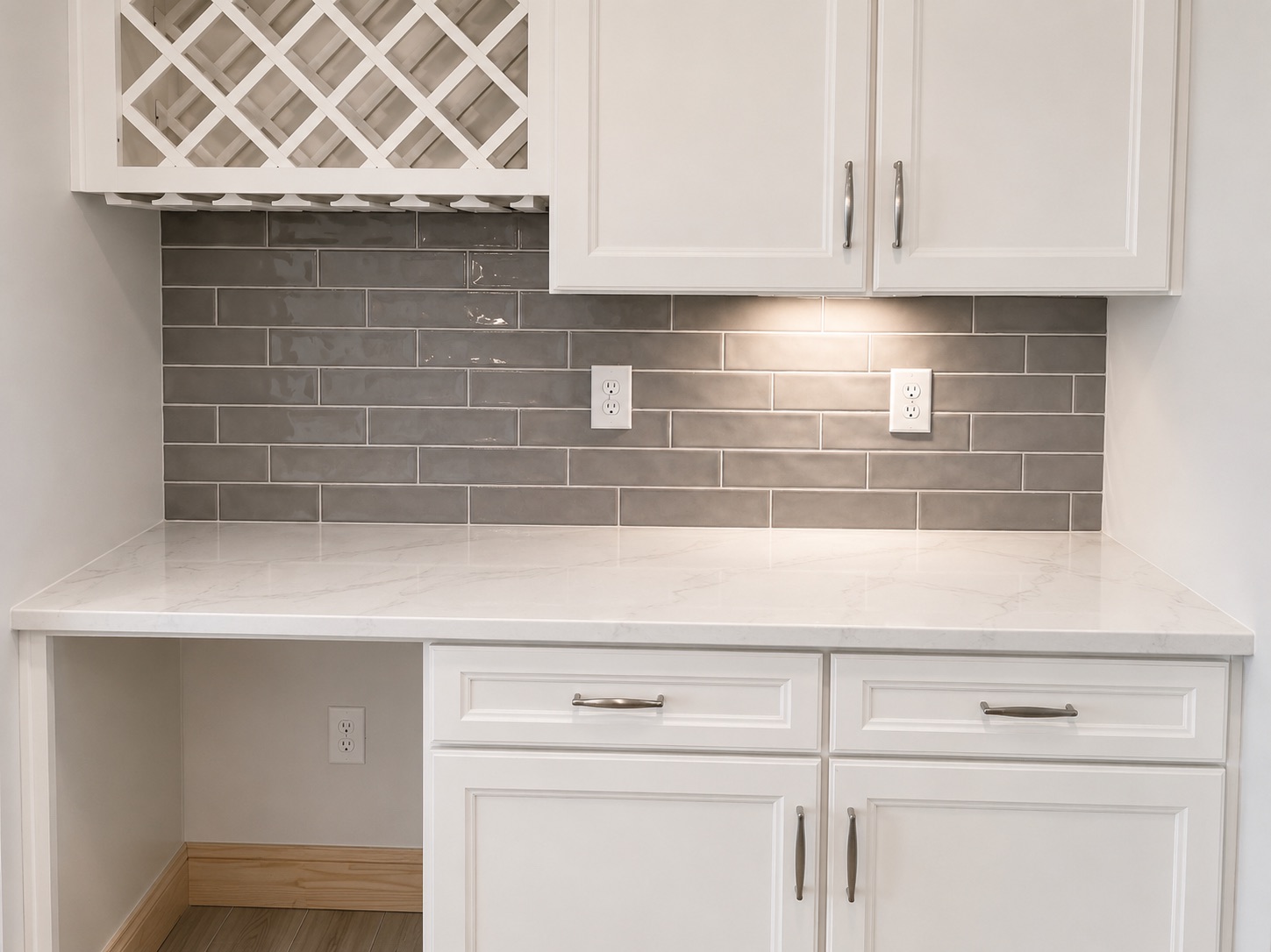 Kitchen area with gray backsplash, quartz counter and wine rack