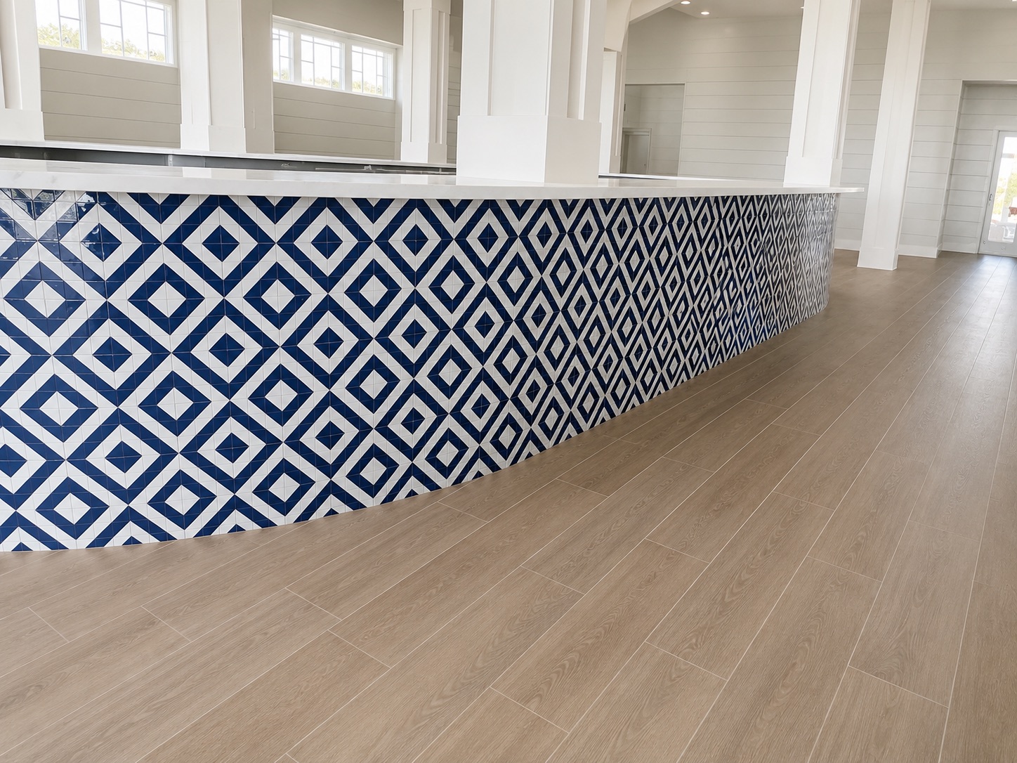 Curved bar with blue and white diamond-pattern tile and wood floor